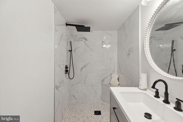 bathroom featuring tiled shower and vanity