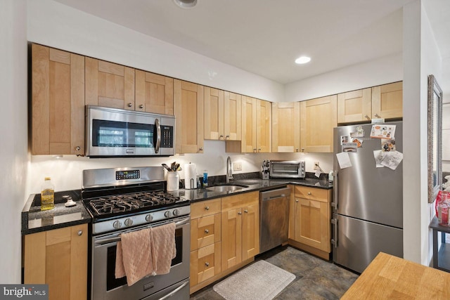 kitchen with sink, dark tile patterned flooring, light brown cabinets, and stainless steel appliances