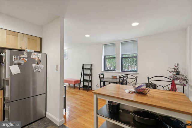 kitchen featuring light hardwood / wood-style floors, stainless steel fridge, and light brown cabinets