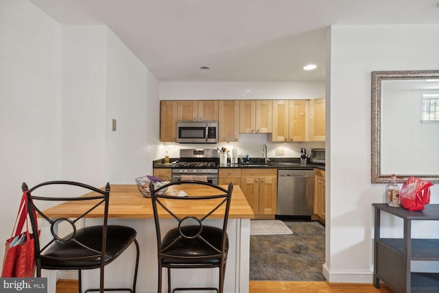 kitchen with sink, dark tile patterned floors, and stainless steel appliances