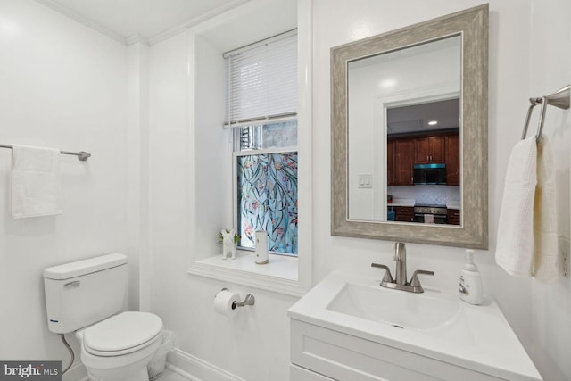 bathroom featuring ornamental molding, vanity, and toilet