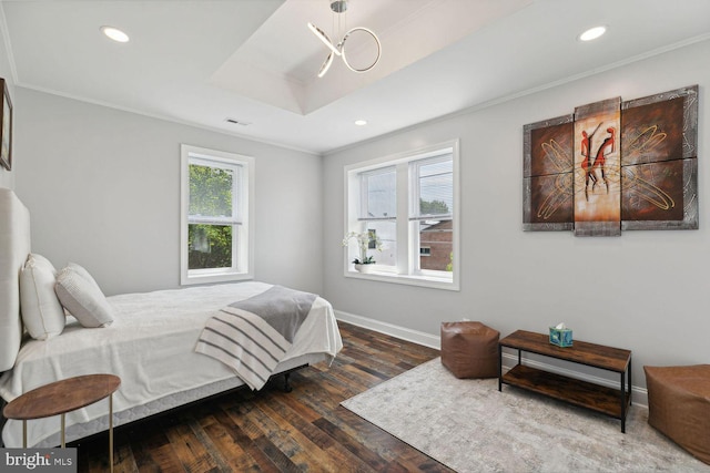 bedroom featuring hardwood / wood-style flooring, crown molding, a tray ceiling, and multiple windows