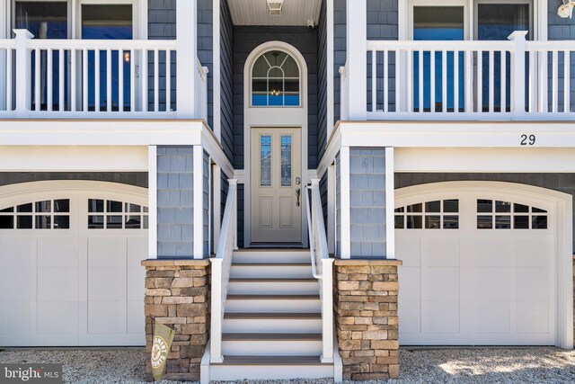 property entrance featuring a balcony and a garage