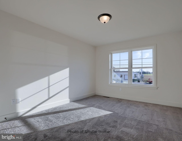 carpeted empty room with baseboards