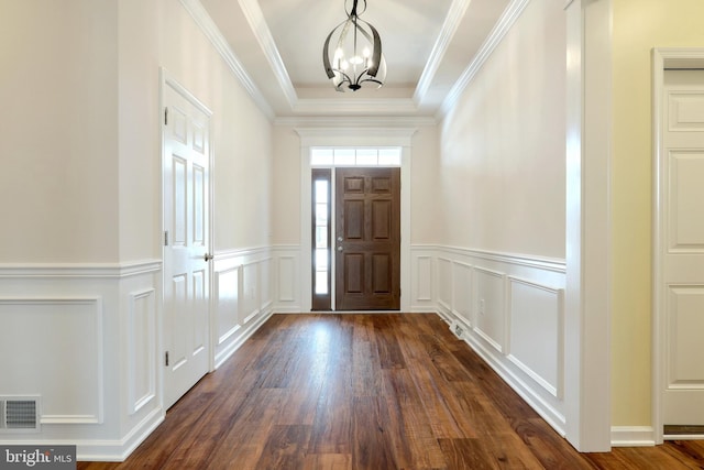 foyer entrance featuring dark hardwood / wood-style flooring, a notable chandelier, and crown molding