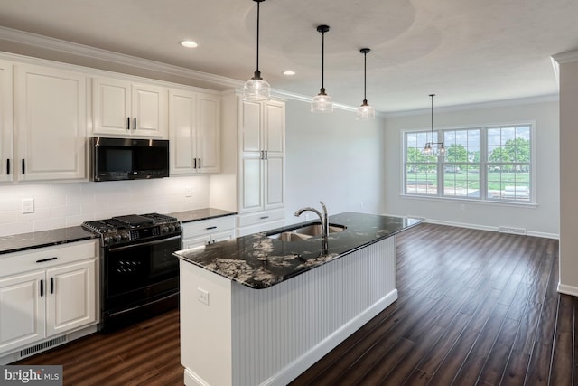 kitchen with dark hardwood / wood-style floors, tasteful backsplash, ornamental molding, black appliances, and a center island with sink