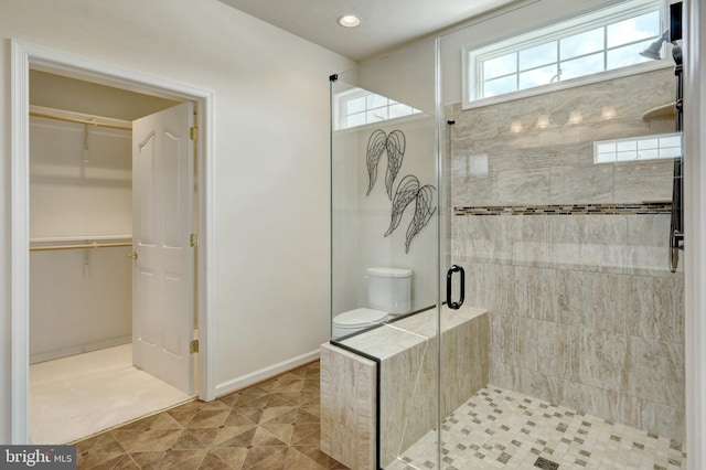 bathroom with tile patterned flooring, toilet, and walk in shower