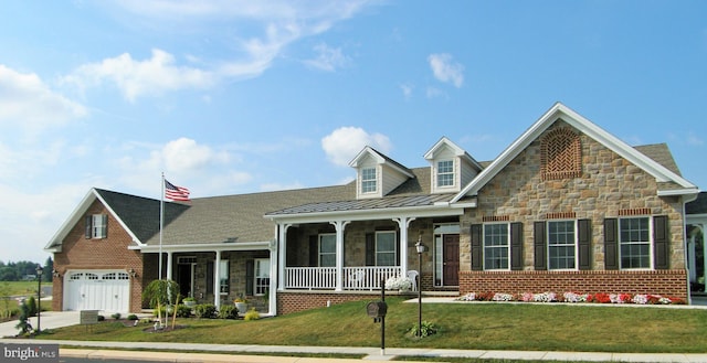 view of front of home with a front lawn, a garage, and covered porch