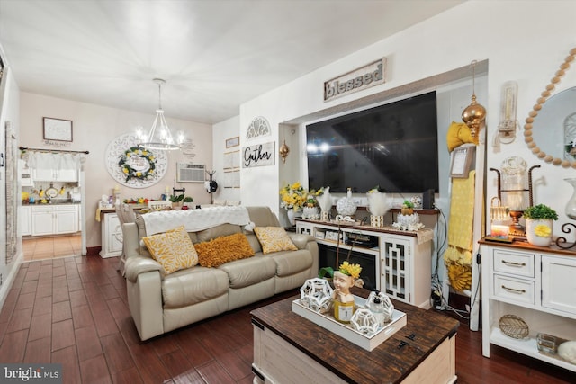 living room with dark hardwood / wood-style flooring, an AC wall unit, and an inviting chandelier