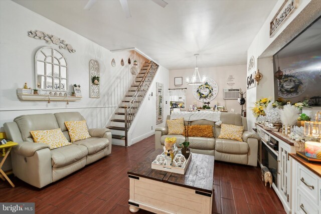 living room with dark hardwood / wood-style flooring, an AC wall unit, and ceiling fan with notable chandelier