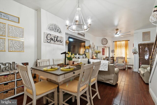 dining area with ceiling fan with notable chandelier and dark hardwood / wood-style floors