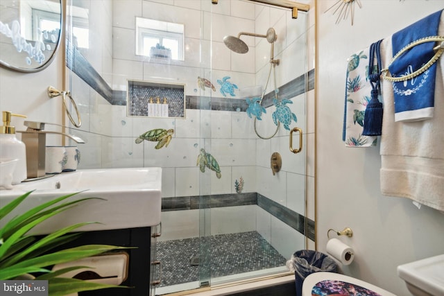 bathroom with a shower with shower door, toilet, and vanity