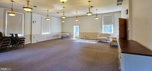 sitting room featuring crown molding, a baseboard radiator, and dark colored carpet