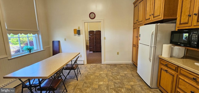 kitchen featuring white fridge and a baseboard heating unit