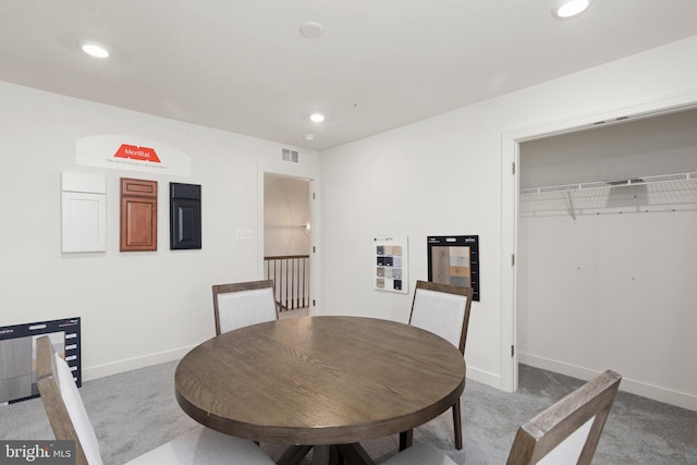 dining space featuring light carpet