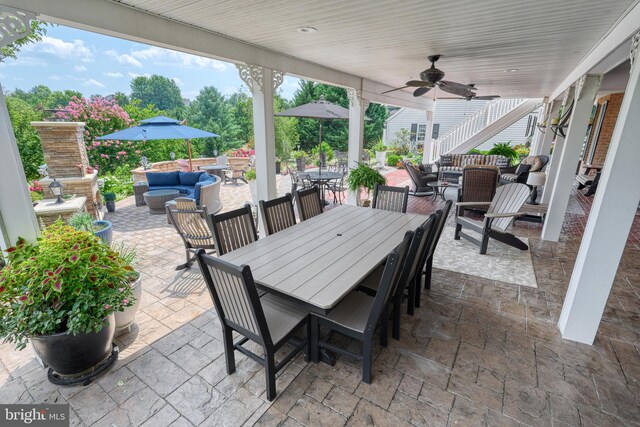 view of patio with stairs, outdoor dining space, an outdoor living space, and a ceiling fan