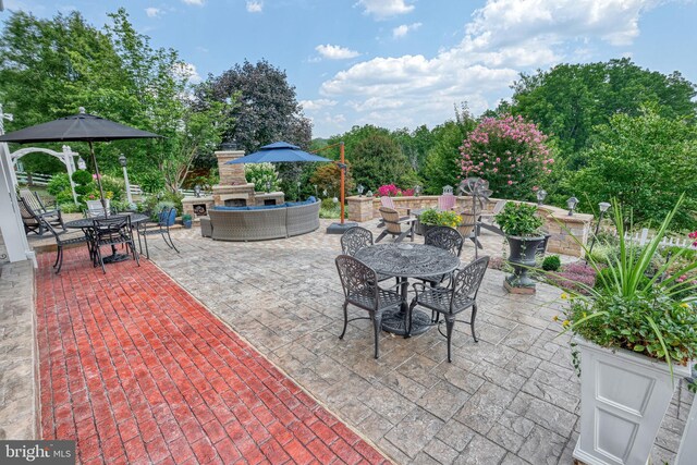 view of patio featuring outdoor dining area and an outdoor living space with a fireplace