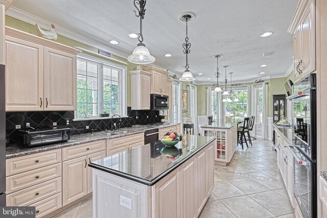 kitchen with wall oven, pendant lighting, a sink, and a center island