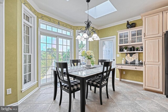 dining area featuring baseboards, a skylight, an inviting chandelier, and crown molding