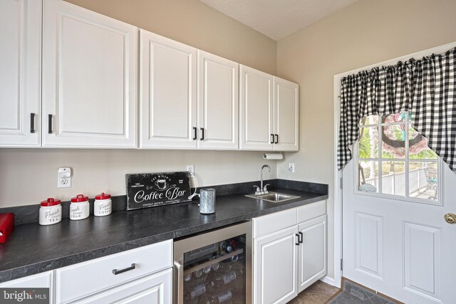 bar featuring beverage cooler and a sink