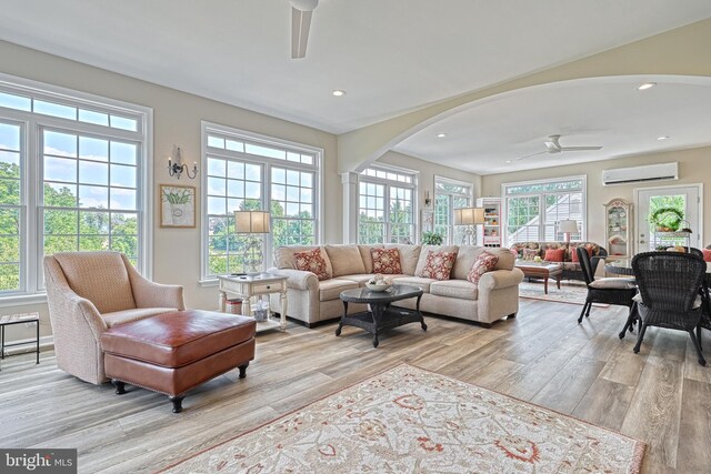 interior space featuring a ceiling fan, arched walkways, and a wall mounted air conditioner