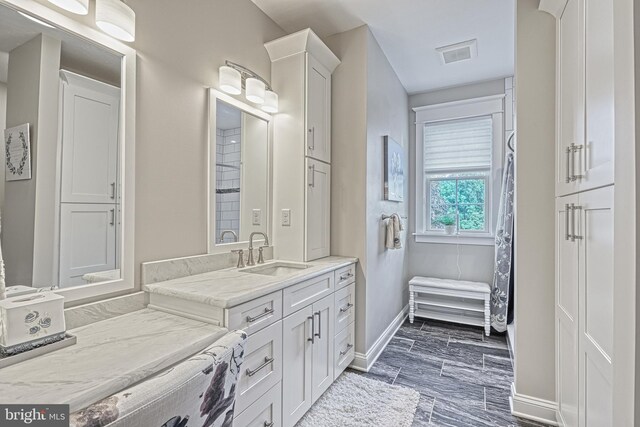 bathroom featuring baseboards, visible vents, and vanity