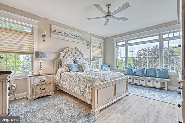 bedroom featuring a ceiling fan, baseboards, and light wood finished floors