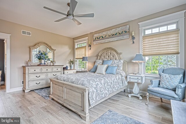 bedroom featuring light wood-style floors, visible vents, baseboards, and a ceiling fan