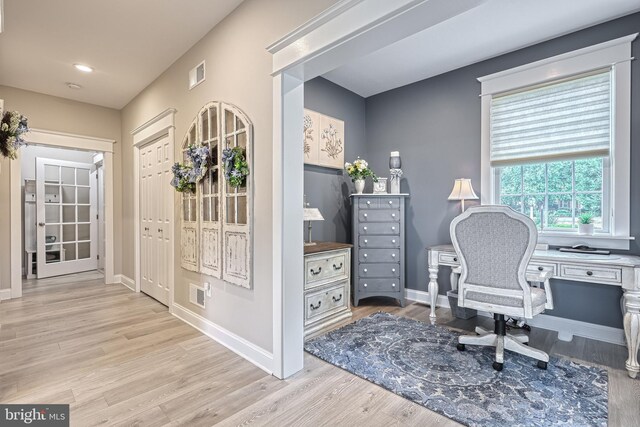 home office featuring light wood-style floors, baseboards, and visible vents