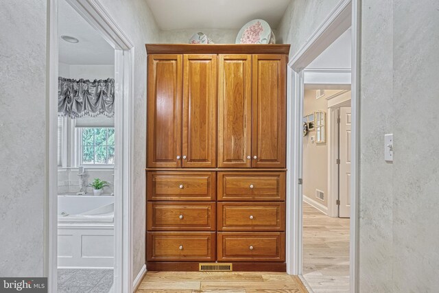 interior space with light wood finished floors and visible vents