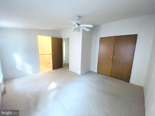 unfurnished bedroom featuring a closet, ceiling fan, and connected bathroom