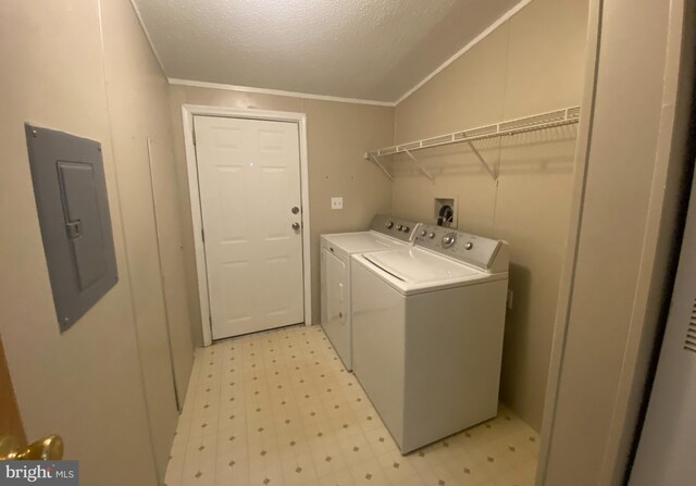 clothes washing area with washing machine and clothes dryer, electric panel, a textured ceiling, and crown molding