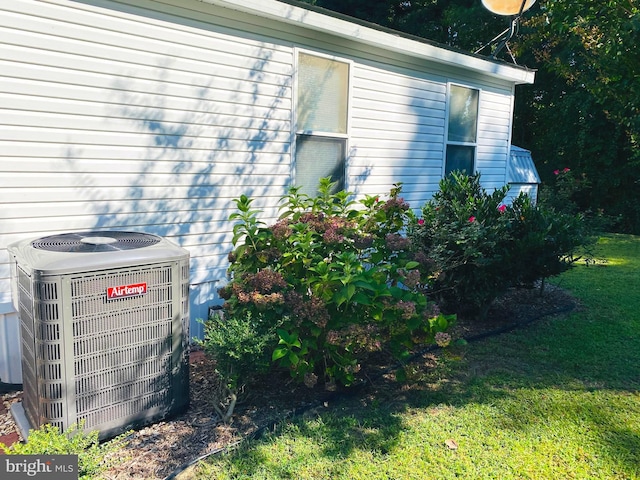 view of property exterior with a yard and central AC unit