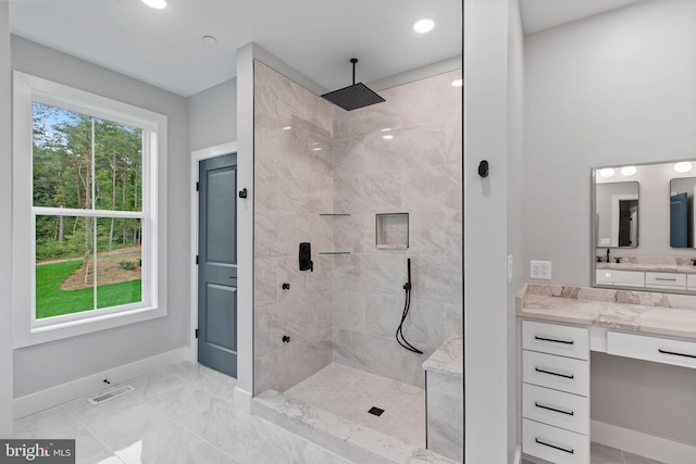 bathroom with vanity and a tile shower