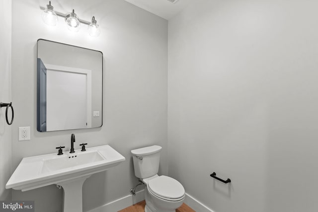 bathroom featuring hardwood / wood-style flooring and toilet