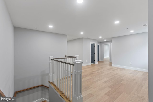 corridor with light hardwood / wood-style floors