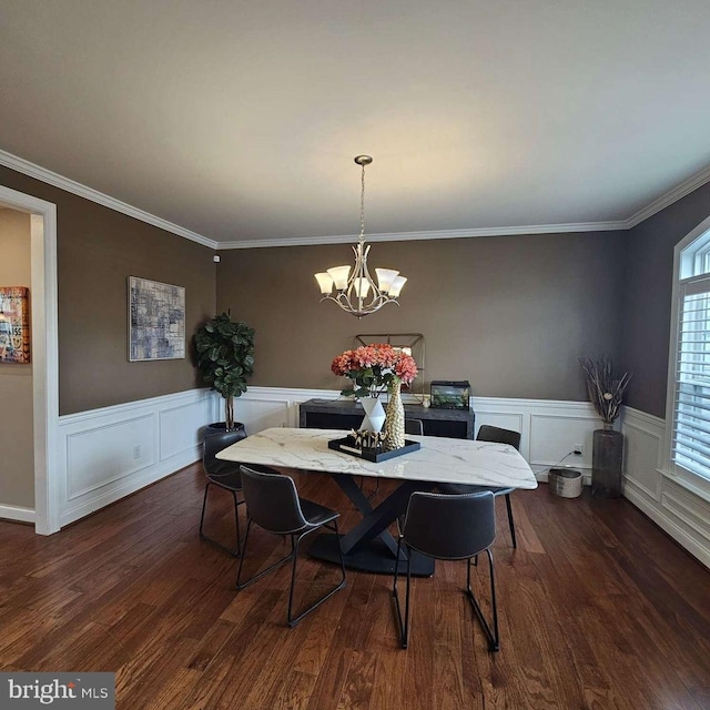 dining space featuring a notable chandelier, ornamental molding, and dark wood-type flooring