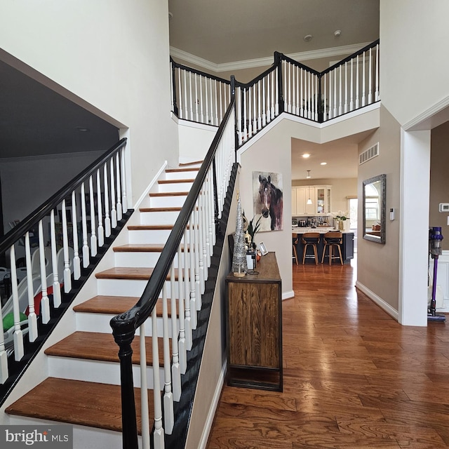 stairway featuring hardwood / wood-style floors and a towering ceiling