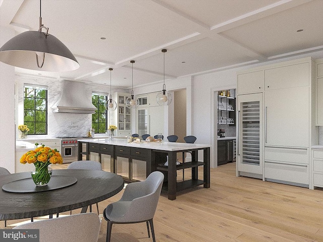 dining room with light hardwood / wood-style flooring, beverage cooler, and coffered ceiling