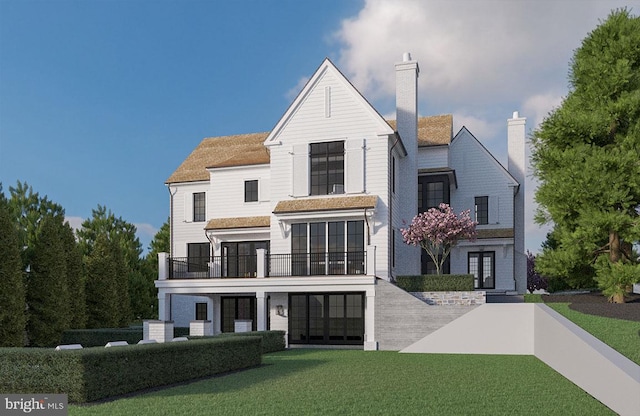 view of front facade featuring a chimney, a balcony, and a front lawn