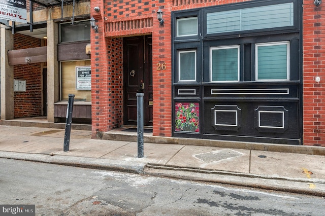 doorway to property with brick siding