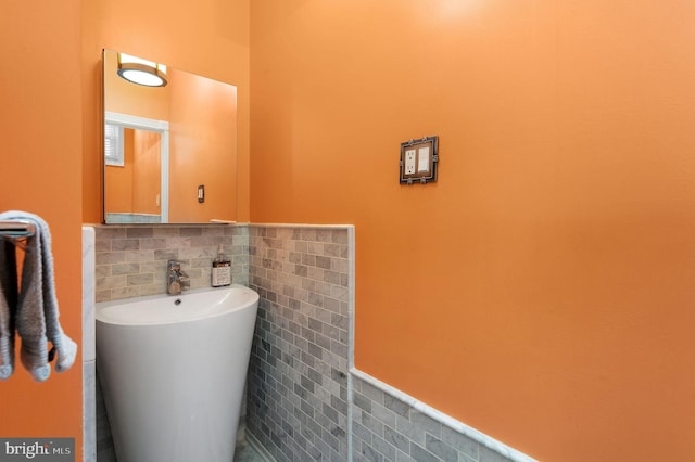 bathroom featuring wainscoting and tile walls