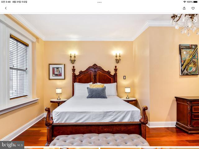 bedroom featuring ornamental molding and wood-type flooring