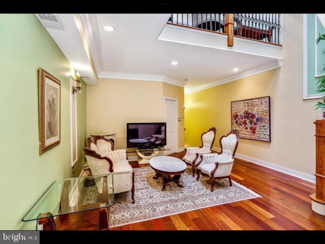 living room featuring crown molding and wood-type flooring