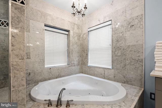 full bath with a notable chandelier and a jetted tub