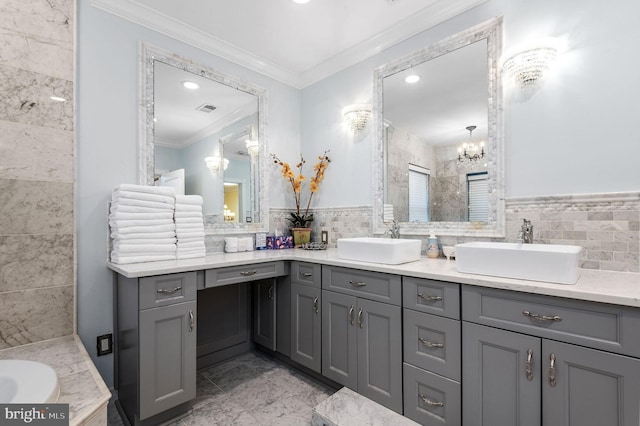 bathroom featuring visible vents, a sink, and tile walls