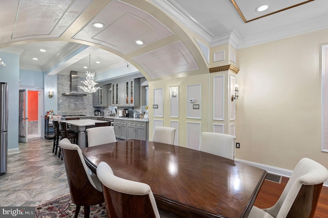 dining room with arched walkways, ornamental molding, visible vents, and an inviting chandelier