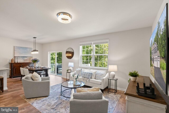 living room with light wood-type flooring and a chandelier