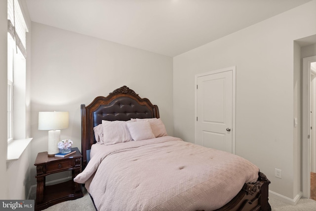 bedroom featuring light colored carpet and baseboards