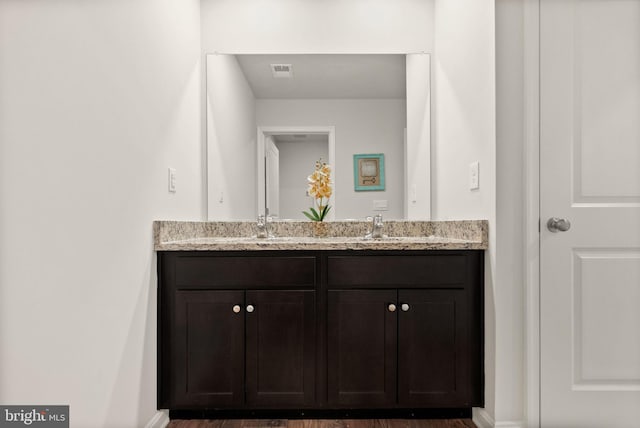 bathroom featuring double vanity, a sink, and visible vents